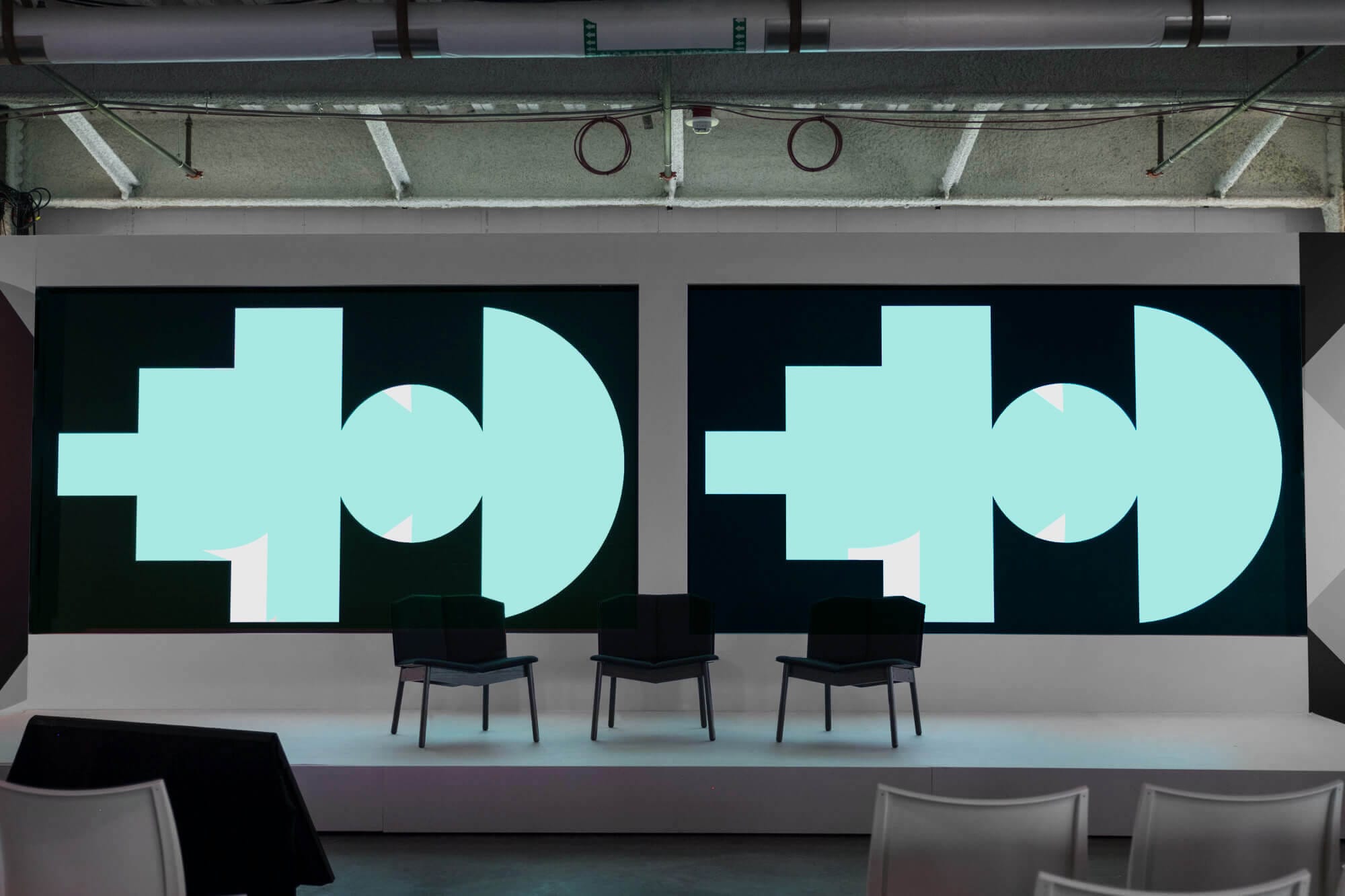 Photo of a stage with the Google SPAN conference screens on displays