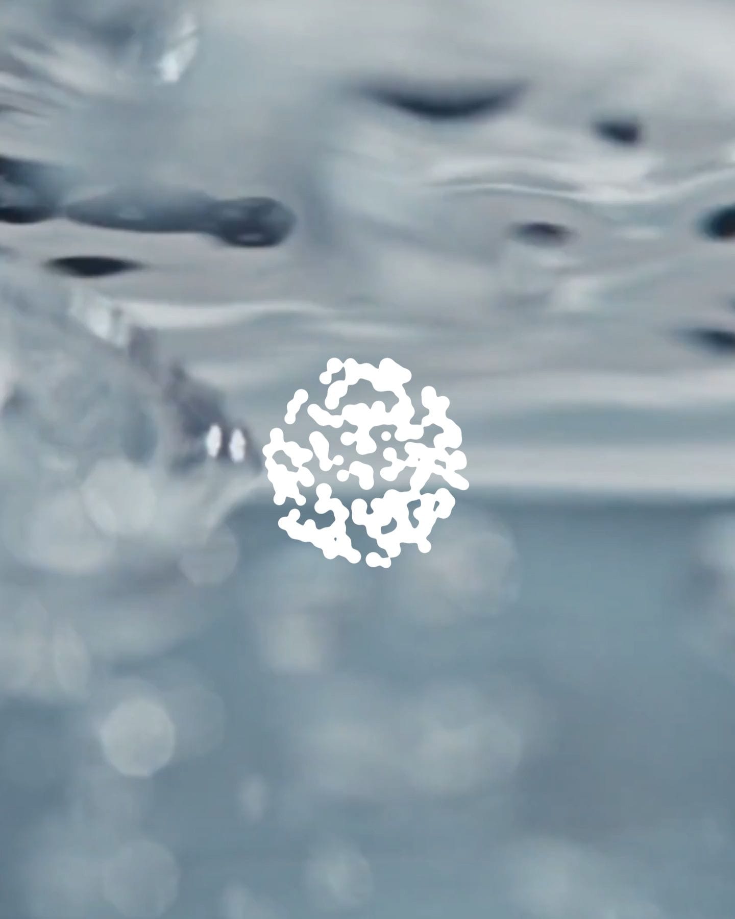 Organic shape made up of smaller elements in front of bubbles moving through liquid.