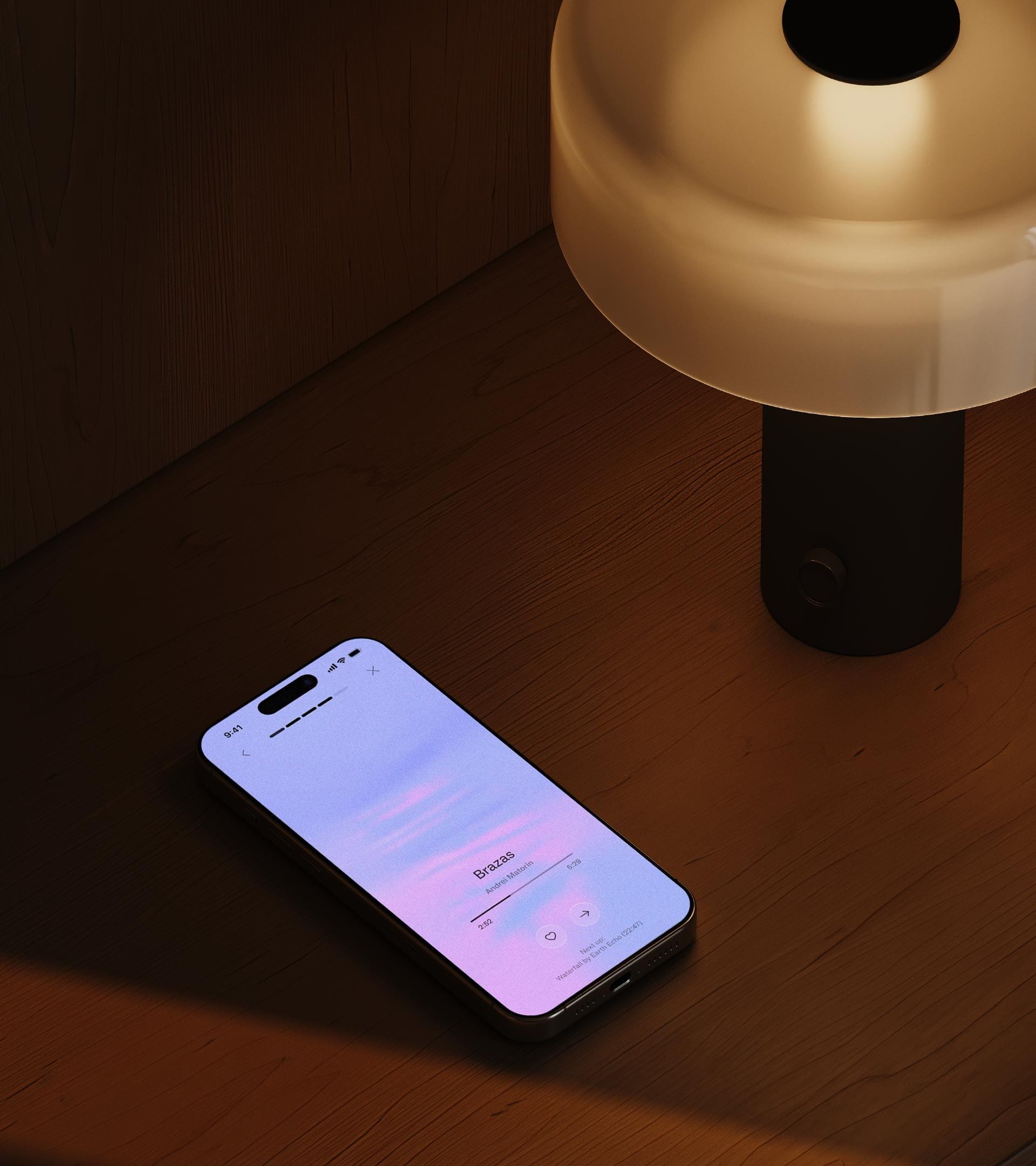 The Thea app open on an iPhone resting beside a warm table lamp at night