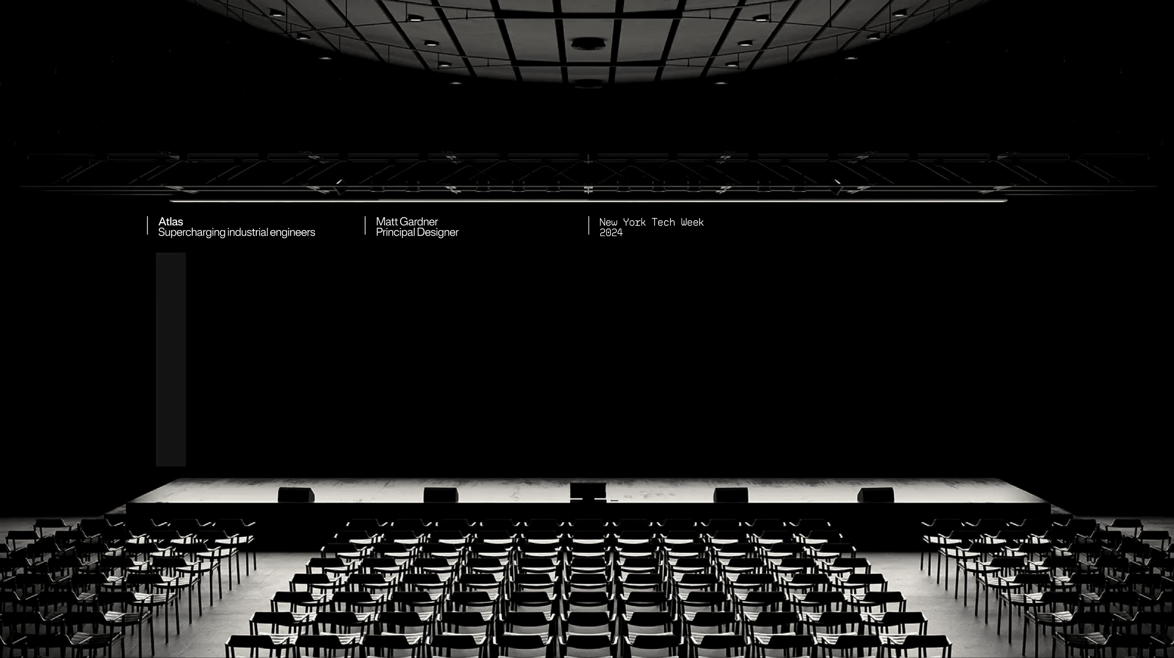 Photo of a dark, empty conference auditorium with rows of black chairs facing the stage, three small credit cards floating mid-frame.