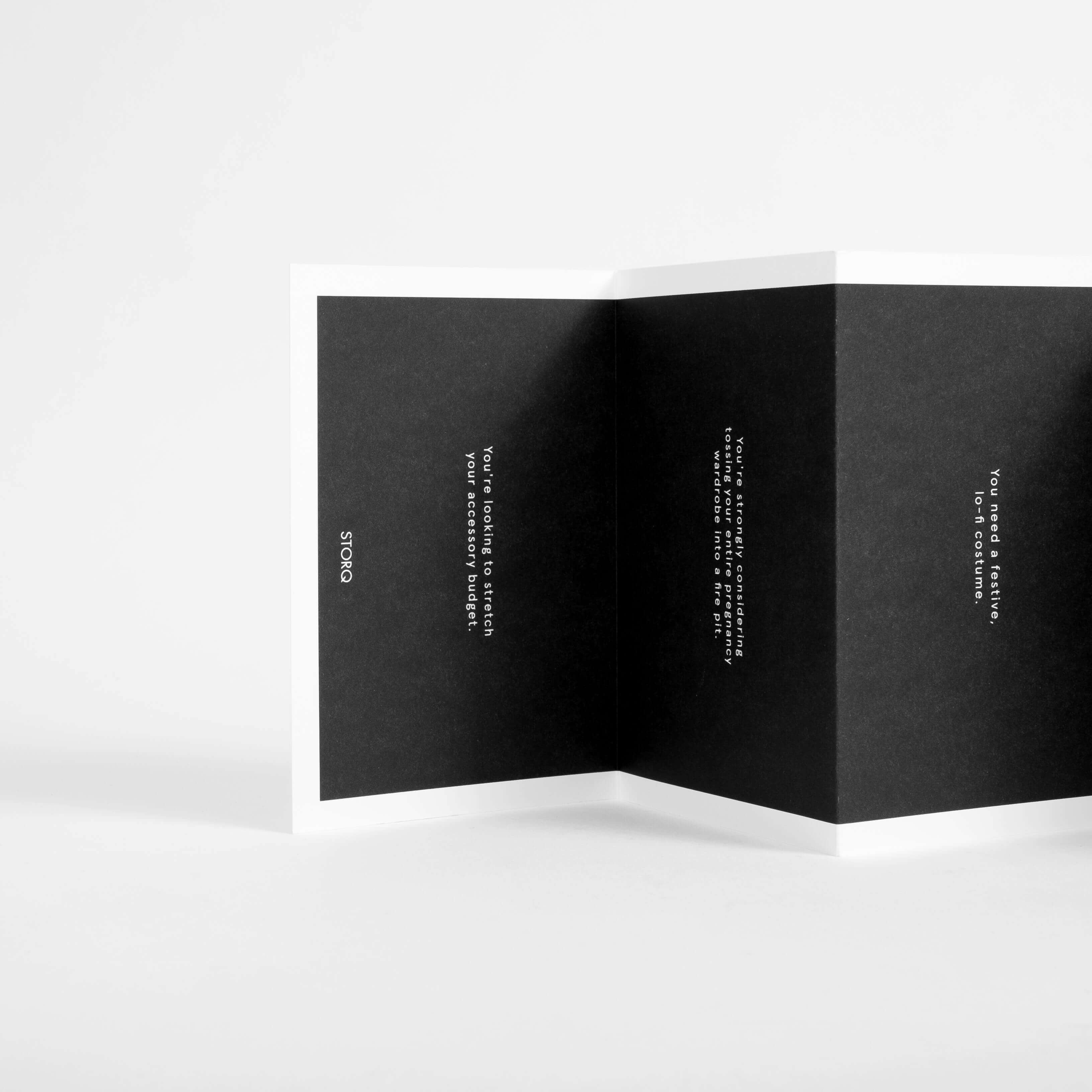 A printed Storq brand booklet open on a neutral surface.